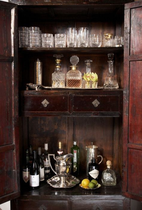 Antique wooden bar cabinet with crystal glassware and bottles